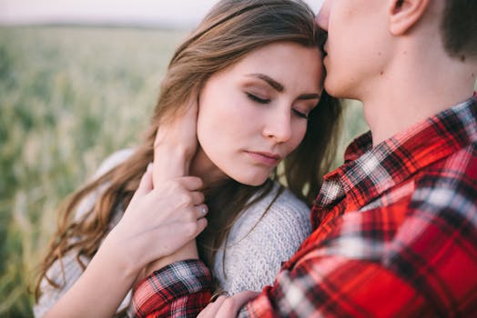 A romantic moment between a couple in a serene outdoor field.