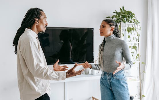 attachment styles in relationships.Young couple discussing relationship issues in a modern living room setting.